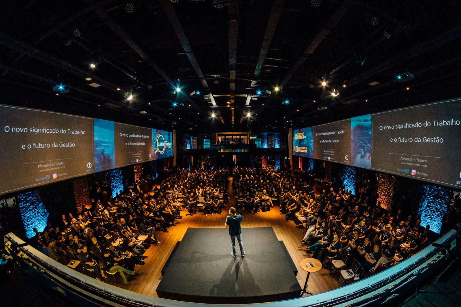 Ponente en el escenario dirigiéndose a un auditorio lleno durante un congreso.