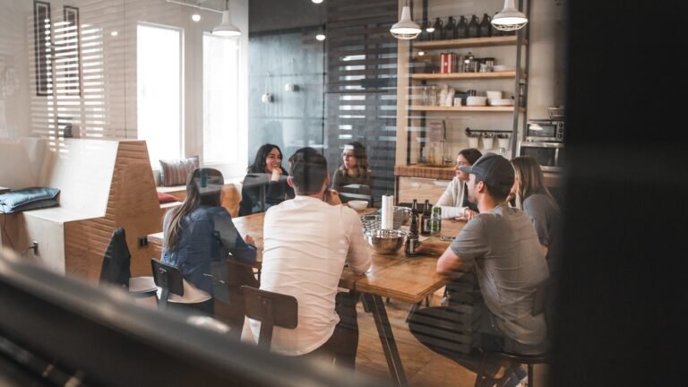 Un grupo de personas reunidas alrededor de una mesa larga de madera.
