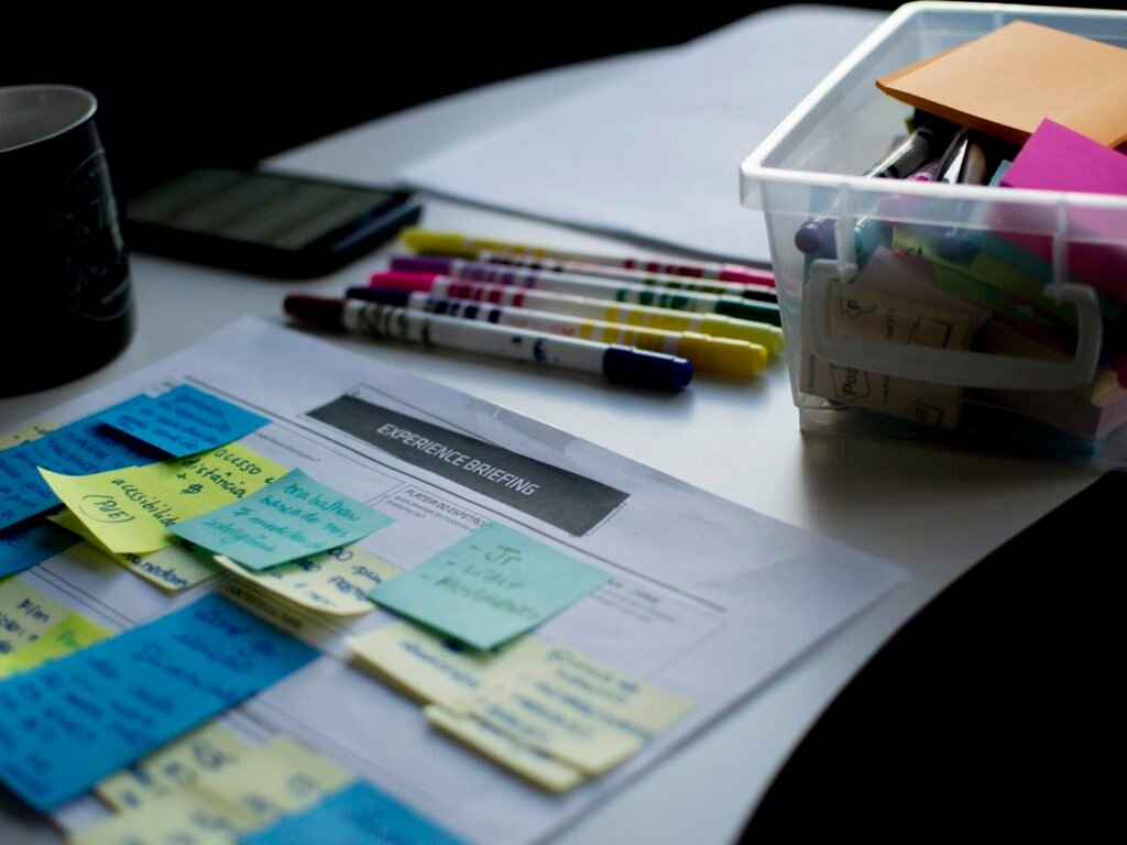 Mesa de trabajo con notas adhesivas de colores sobre el guion de un evento.